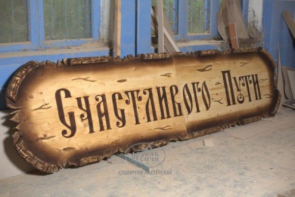 Деревянная вывеска из массива сосны под старину с резьбой фото крупный план 